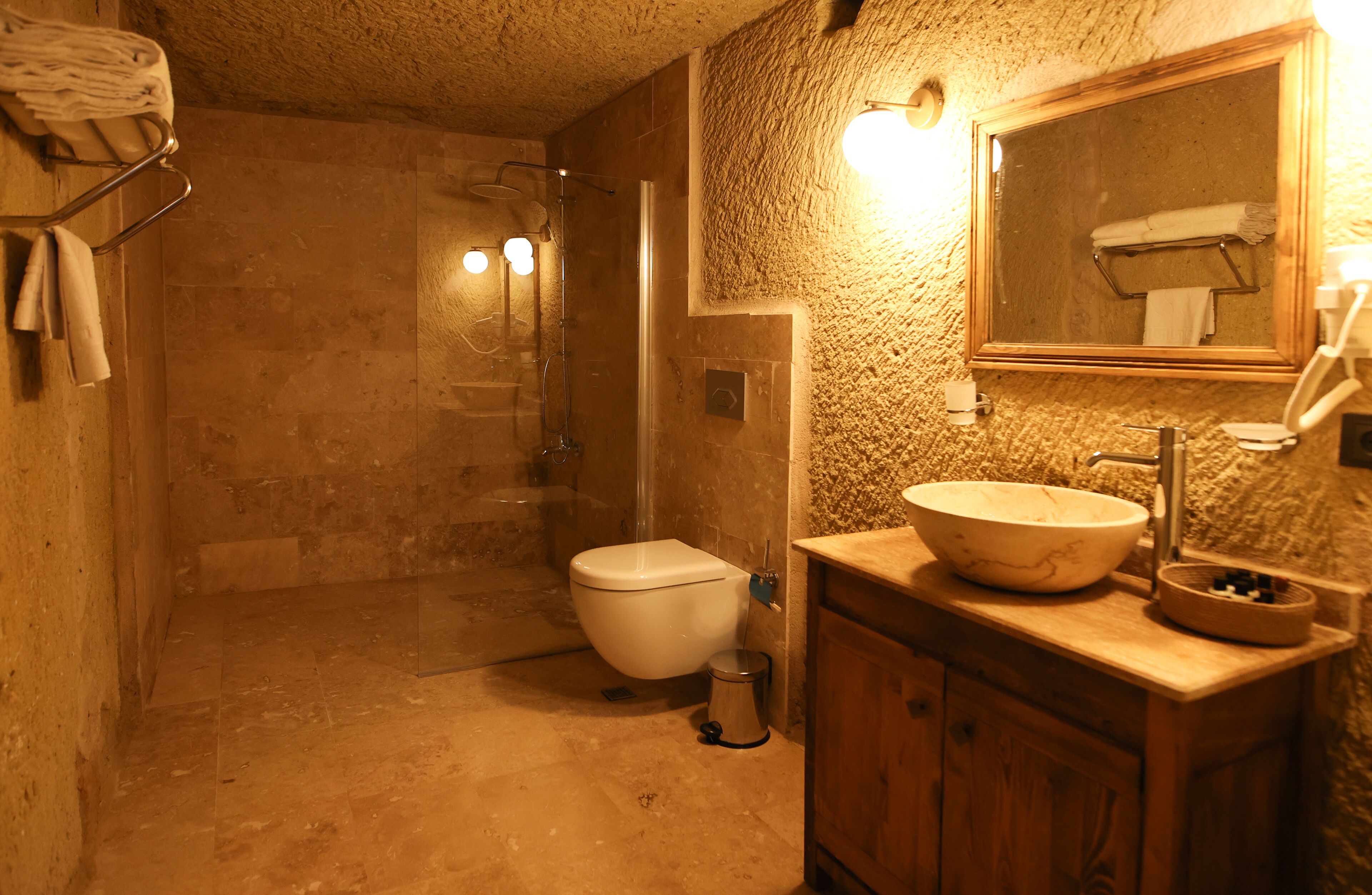 A bathroom with a large sink, a mirror, and a shower.
