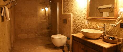 A bathroom with a large sink, a mirror, and a shower.