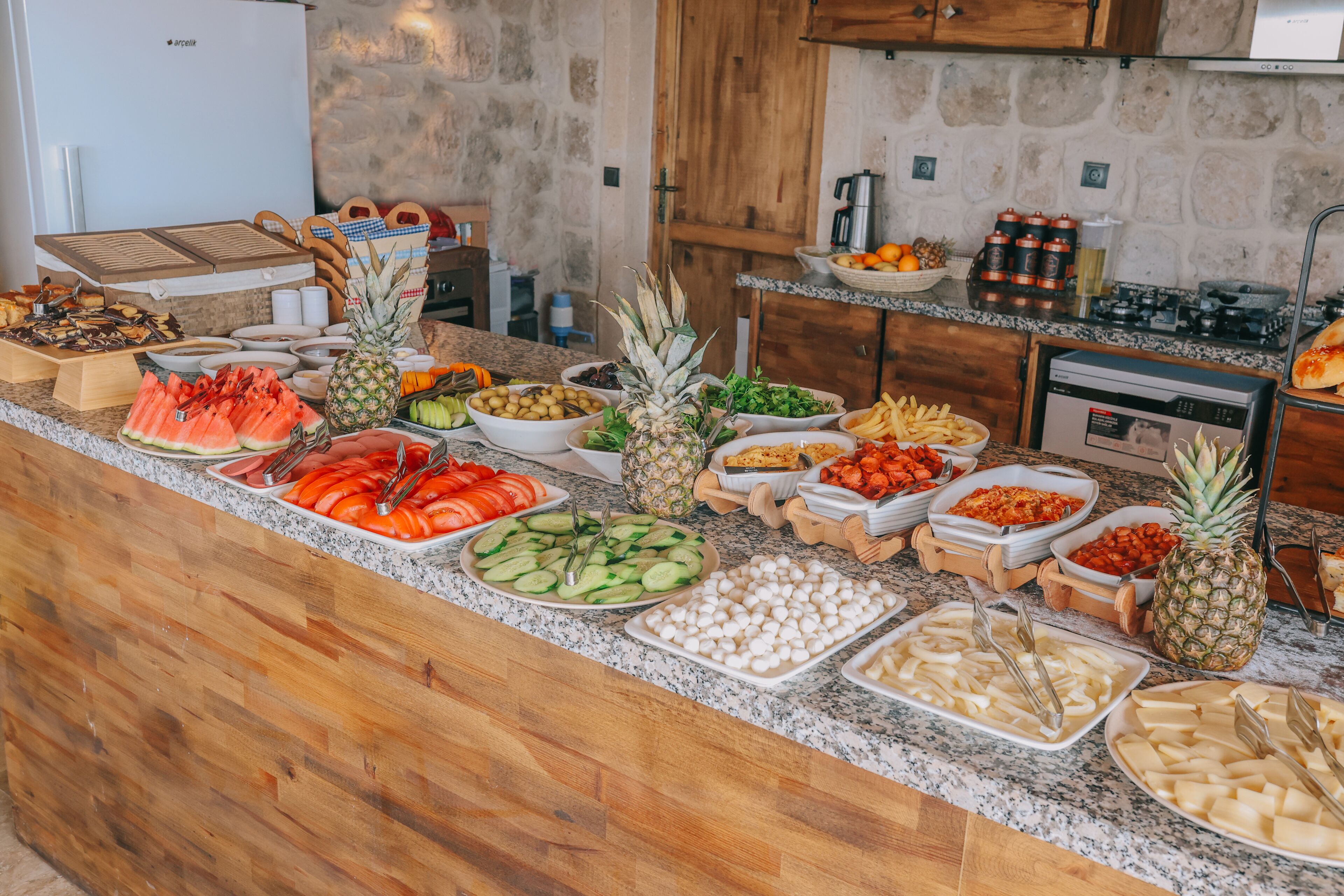 Un bufé con diversas frutas, verduras y quesos.