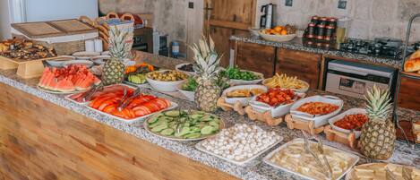 Un bufé con diversas frutas, verduras y quesos.