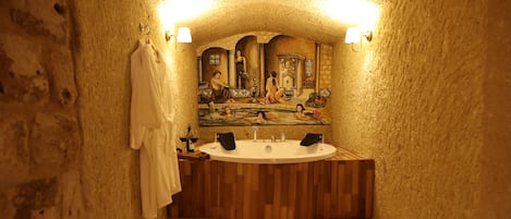 Un baño con tocador de madera, un espejo grande y una bañera.