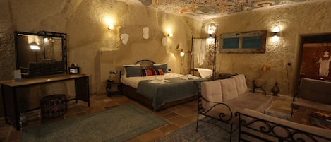 A room with a bed, a sofa, a desk, and a mirror.