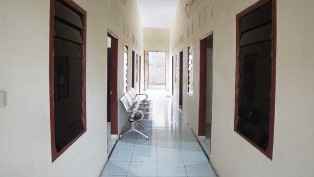 A hallway with a bench, doors, and a tiled floor. - Hotel O Sky Residence Cengkeh (Medan)