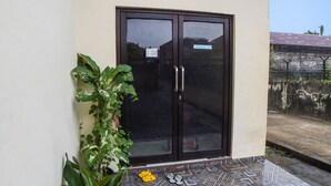 A building entrance with a glass door, a sign, and a tiled floor. - Hotel O Sky Residence Cengkeh (Medan)