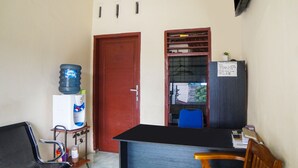 A small office with a desk, chair, water dispenser, and a closed door. - Hotel O Sky Residence Cengkeh (Medan)