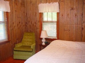 Cozy reading nook with a comfortable bed and plush armchair.