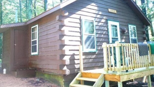 Eine kleine Holzhütte mit Veranda und einem Fenster.
