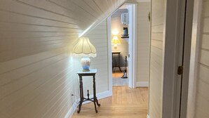 A narrow hallway with wooden flooring and white paneled walls. - Early1880s farmhouse in rural Eastern Kentucky Appalachia. (Booneville)