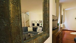 Een moderne woonkamer met een bank, salontafel en een televisie op een houten kast.
