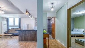 Un apartamento moderno con sala de estar, kitchenette y un dormitorio.