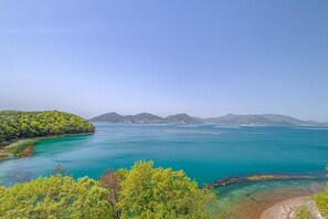A coastal landscape with clear turquoise waters, a sandy beach, and lush greenery. - Geoje Gabaestory Pension (Geoje)