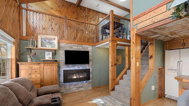 Un salon spacieux avec une cheminée, un escalier en bois et un canapé confortable.