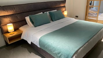 Habitación cuádruple Deluxe | Ropa de cama de alta calidad y camas Select Comfort
