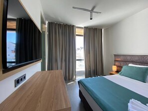 A hotel room with a bed, a desk, a TV, and curtains. - H2O Ureki (Ureki)
