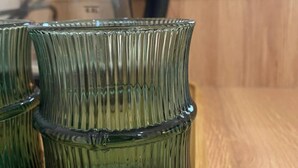 A wooden table with three green glass vases. - H2O Ureki (Ureki)
