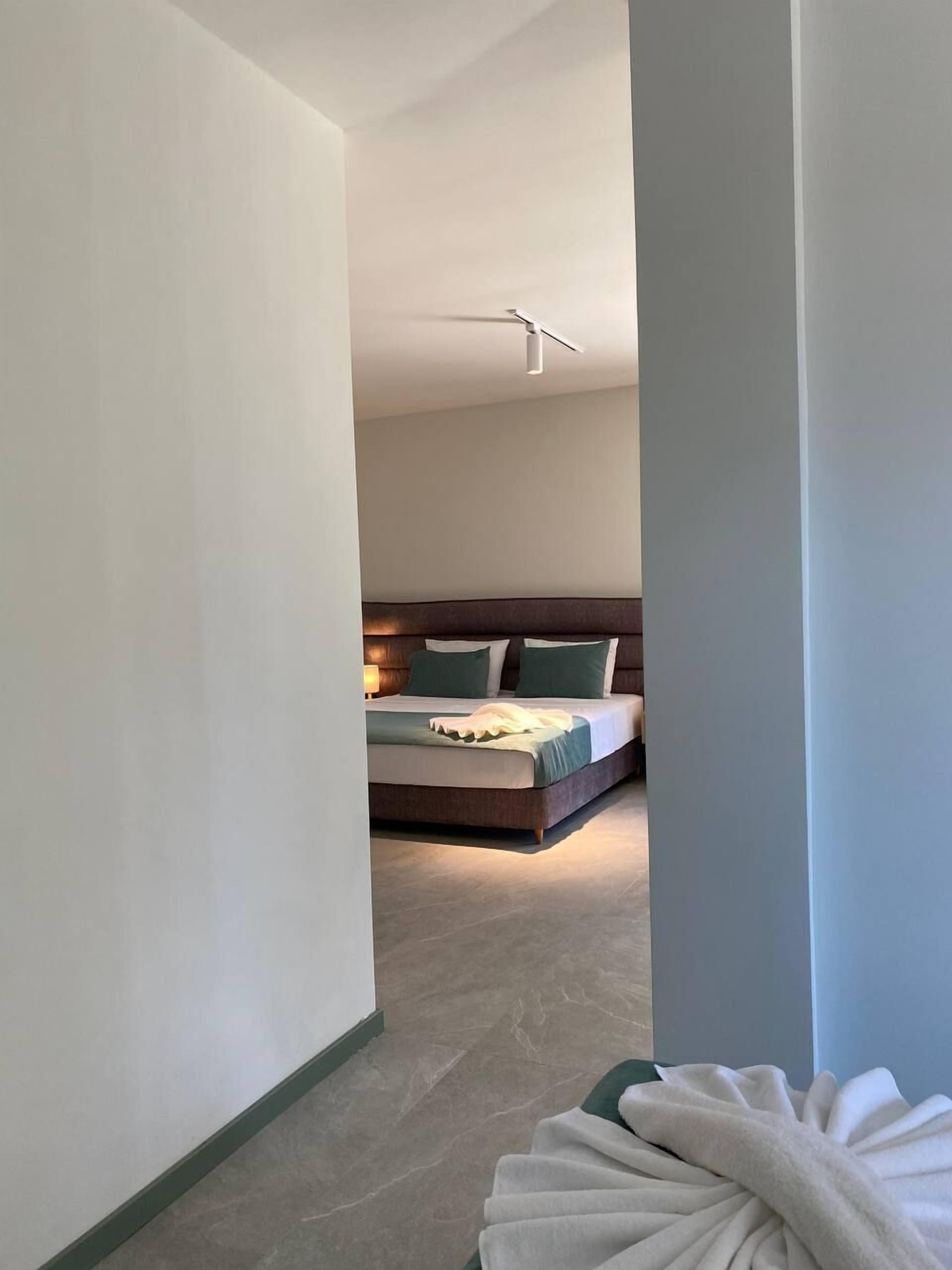 Et moderne hotelværelse med en stor seng, en sengegavl og en loftlampe.