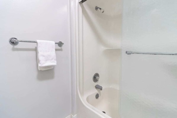 Un baño con bañera, toallero y cortina de ducha.