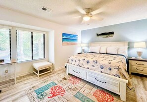 A bedroom with a bed, bedside tables, a bench, a ceiling fan, and a view of the outdoors. - Beachside Luxury Villa, Balcony Views! Hilton Head (Hilton Head Island)
