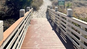 A wooden boardwalk leading to a beach, surrounded by vegetation and a clear sky. - Beachside Luxury Villa, Balcony Views! Hilton Head (Hilton Head Island)