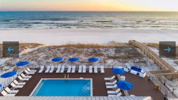 A pool area with lounge chairs and umbrellas, overlooking a beach with a wooden walkway. - Salty and Sweet at Perdido Key  SLEEPS 8! Two pools and a state-of-the-art gym (Pensacola)