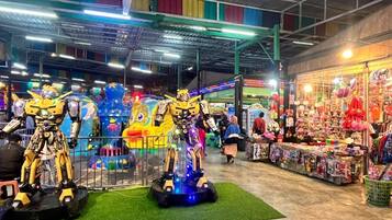 Un amplio espacio de entretenimiento cubierto con diversas atracciones y una tienda de recuerdos.