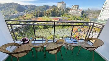 Relax on the balcony with a view of the surrounding hills and buildings.