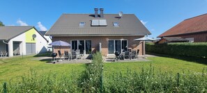 A house with a patio area, outdoor seating, and a garage.