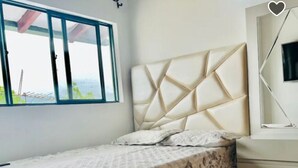 A bedroom with a bed, a window, and a mirror. - CENTRAL APARTMENT IN POPAYAN (Popayán)