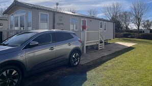 A single-story mobile home with a car parked in front. - Prestige pet Friendly Caravan on Butlins, Skegness (Skegness)