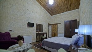 Una habitación con cama, escritorio, sillón y sofá.