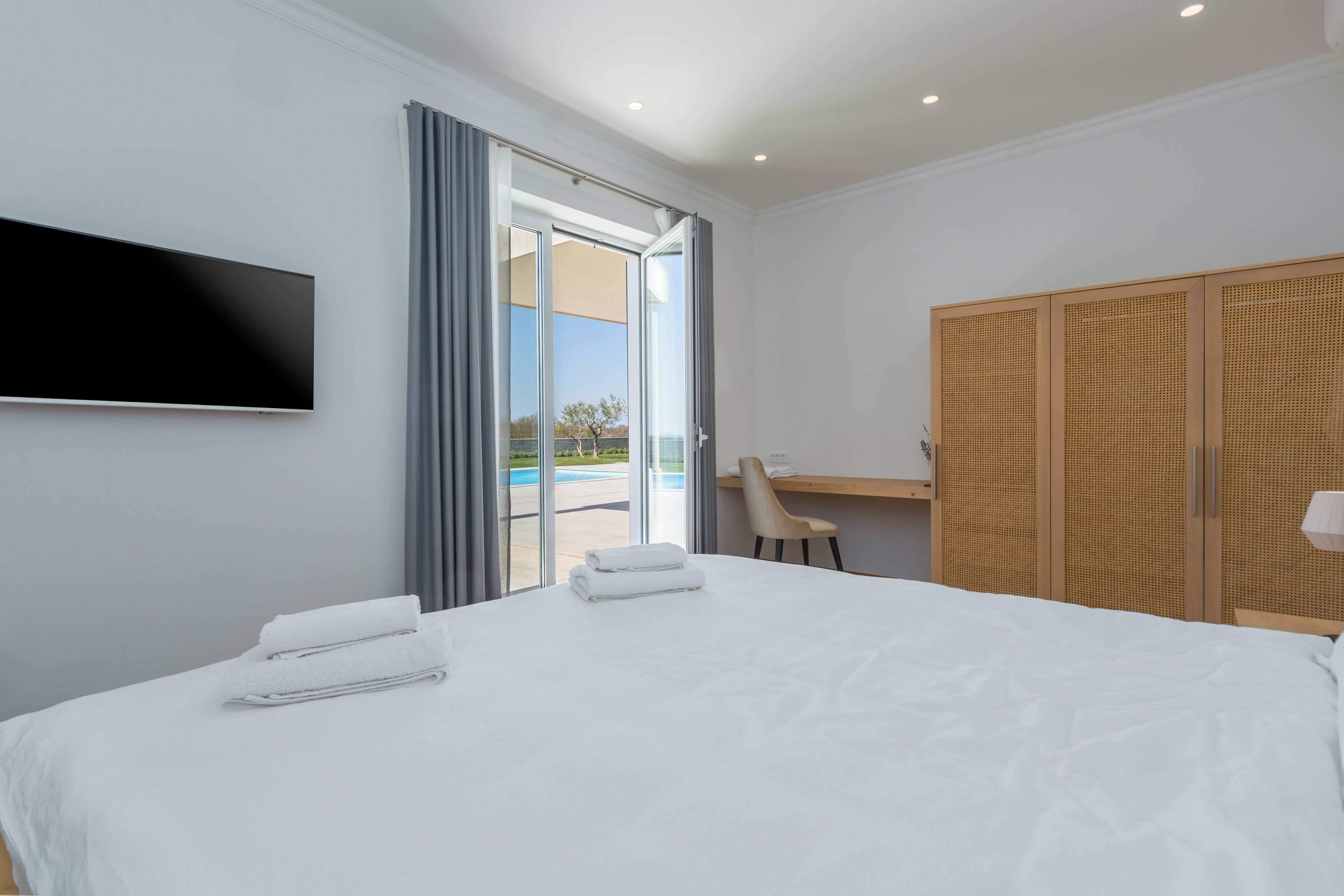 Une chambre d’hôtel équipée d’un lit, d’un téléviseur fixé au mur, d’un bureau et d’une armoire.