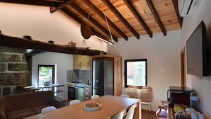 Eine moderne Küche mit Holzboden, Steinwänden und einem Essbereich mit einem Holztisch und Stühlen.