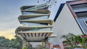 A modern hotel with a unique curved facade and a prominent 'Hotel Elysee' sign. - Treebo Elysee, Patel Nagar (Dehradun)