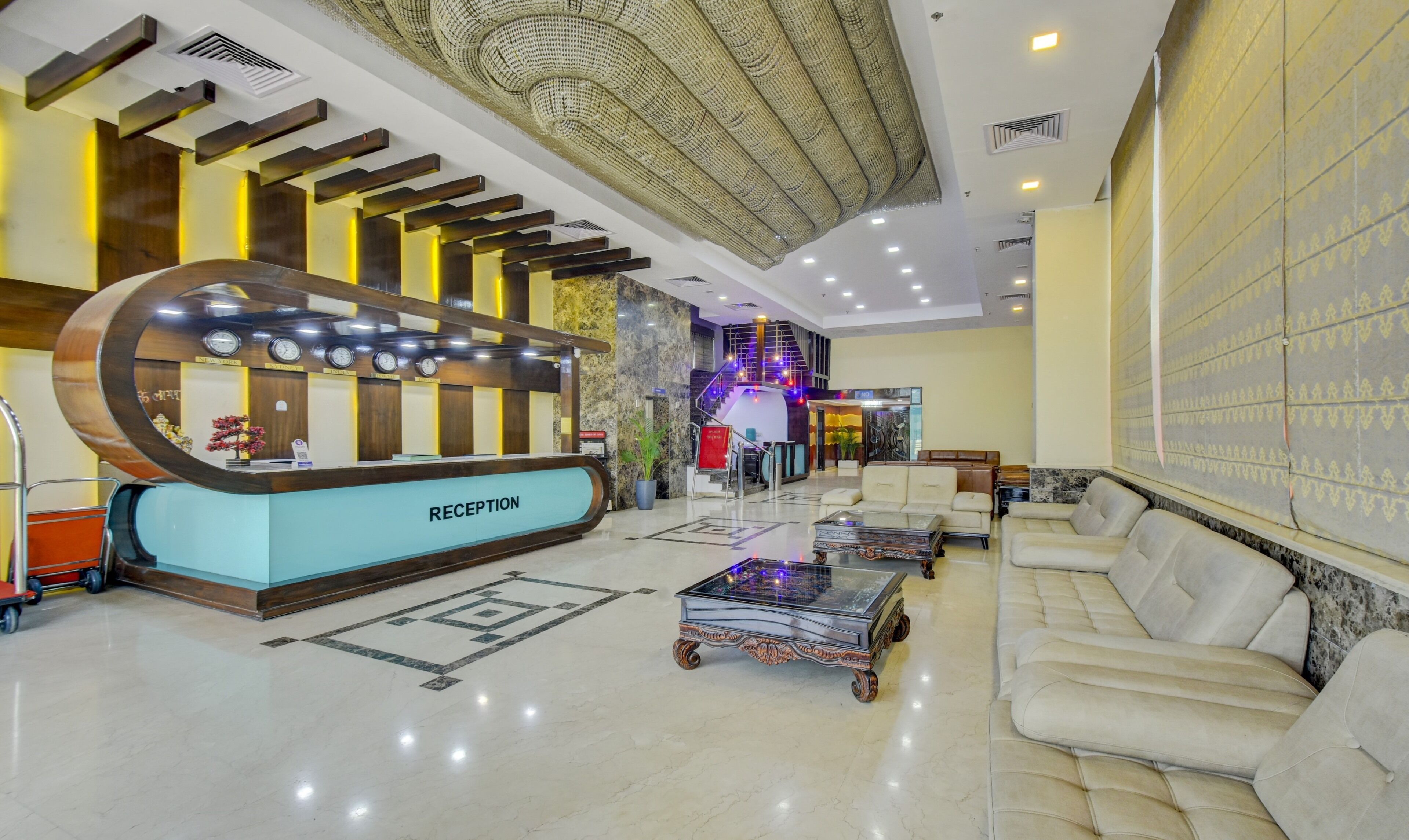 A reception area with a modern design, including a reception desk, seating area, and a staircase leading to an upper level.