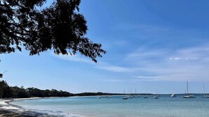 A beach with clear blue water, boats, and a sandy shore. - Tulum Hideaway – Steps to Water, Close to Trails (Callala Bay)