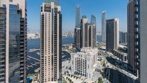 Zona urbana con rascacielos, edificios modernos, un puerto deportivo y cielo azul despejado.