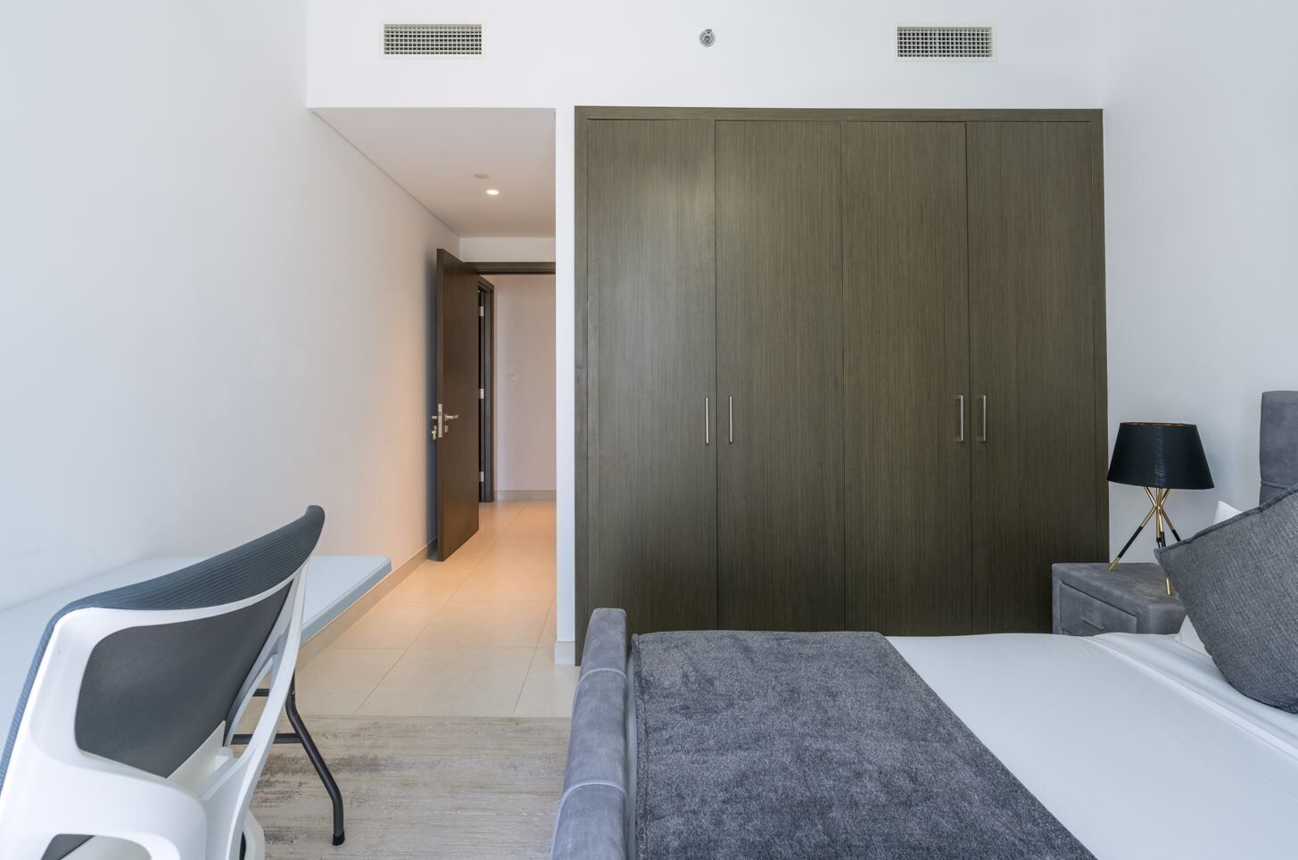 Une chambre moderne avec un lit, un bureau et une armoire.