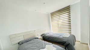 A bedroom with two beds, each with grey bedding and white towels. - 3084 Res. MAUI II (Orihuela)