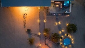 Vista aérea de uma propriedade com piscina, iluminação externa e área de pátio.