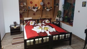 Un dormitorio con una cama de madera, una mesita de noche, una estantería y una planta en maceta.