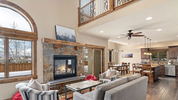 A spacious living area with a fireplace, comfortable seating, a dining area, and a kitchen. - Cherry Drive 4 Bedroom Home by RedAwning (Steamboat Springs)