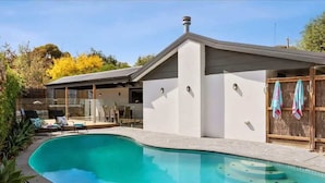 A modern house with a swimming pool, a covered patio, and a fenced yard. - Sunny Daze Haven: SPA and Pool (Ocean Grove)