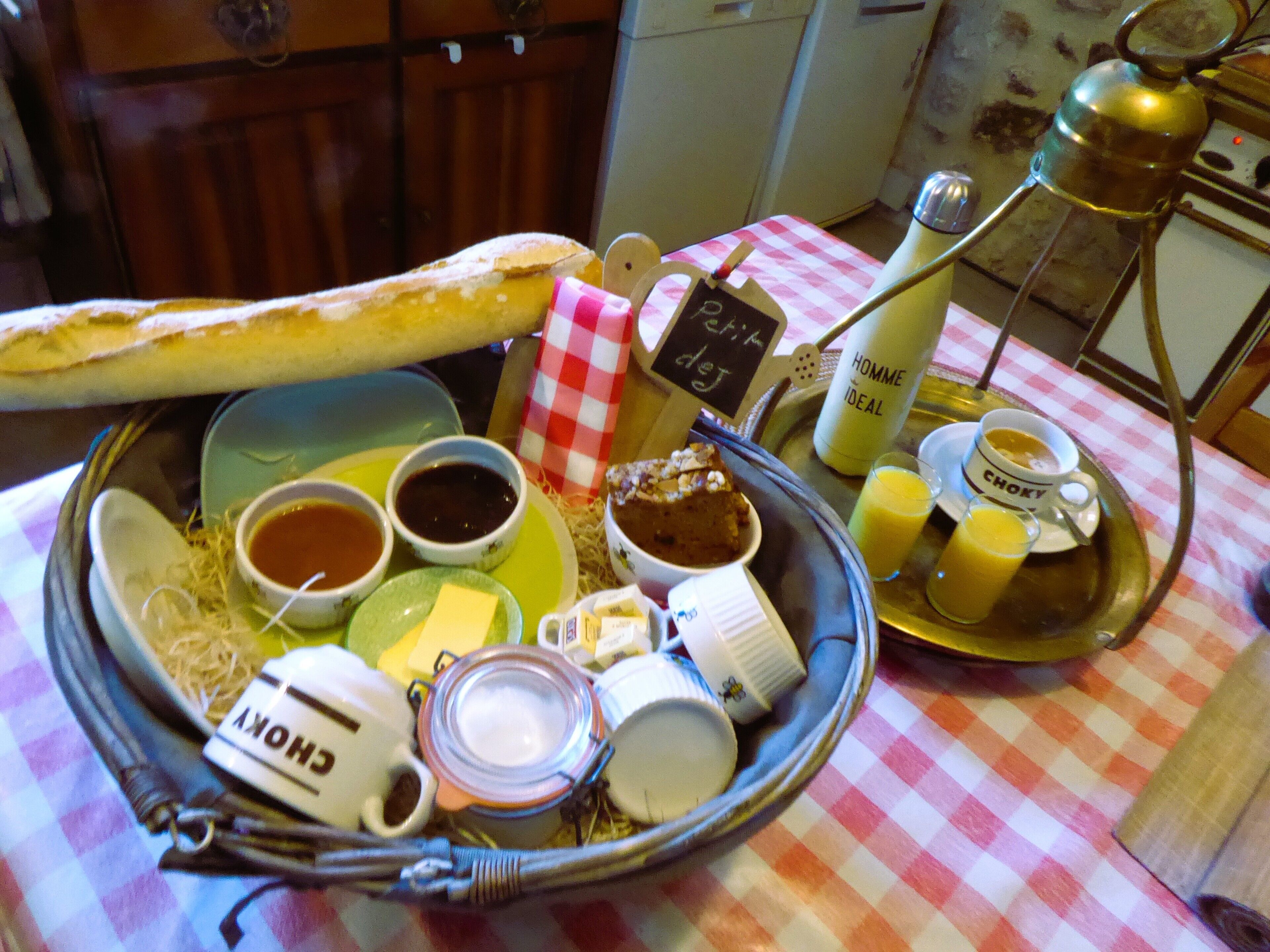 A breakfast tray with bread, butter, jam, coffee, and juice.
