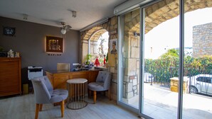 Un vestíbulo de hotel con una recepción, zona de estar y amplios ventanales que ofrecen vistas al exterior.