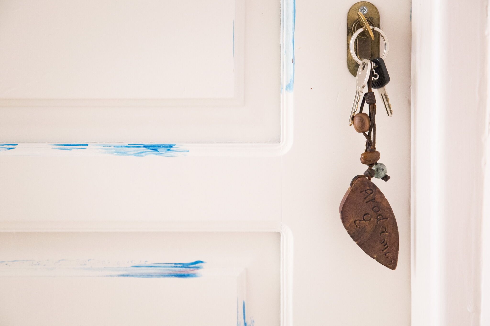 Une porte avec un trou de serrure et un porte-clés contenant des clés et un cadenas.