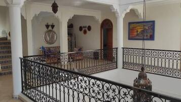Ein geräumiger Innenraum mit Balkon, Treppe und einer Wanduhr.