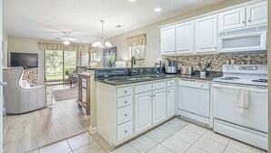 A modern kitchen with white cabinets, a granite countertop, and a built-in oven. - 2 Bed 2Bath 1st Floor Golf and Beach Condo (Pawleys Island)