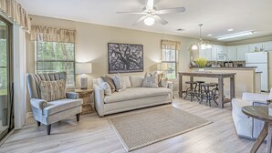 A modern living room with a sofa, armchairs, a coffee table, and a dining area with bar stools. - 2 Bed 2Bath 1st Floor Golf and Beach Condo (Pawleys Island)