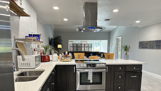A modern kitchen with a built-in oven, a microwave, and a sink. - Florida Vacation Villa with hot tub (Fort Lauderdale)