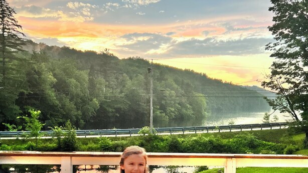 A child standing on a wooden deck with a view of a lake and forested hills in the background. - Beaver's Bend Lakefront Retreat ~16 mi to Slopes & Pet Friendly! (Whitingham)